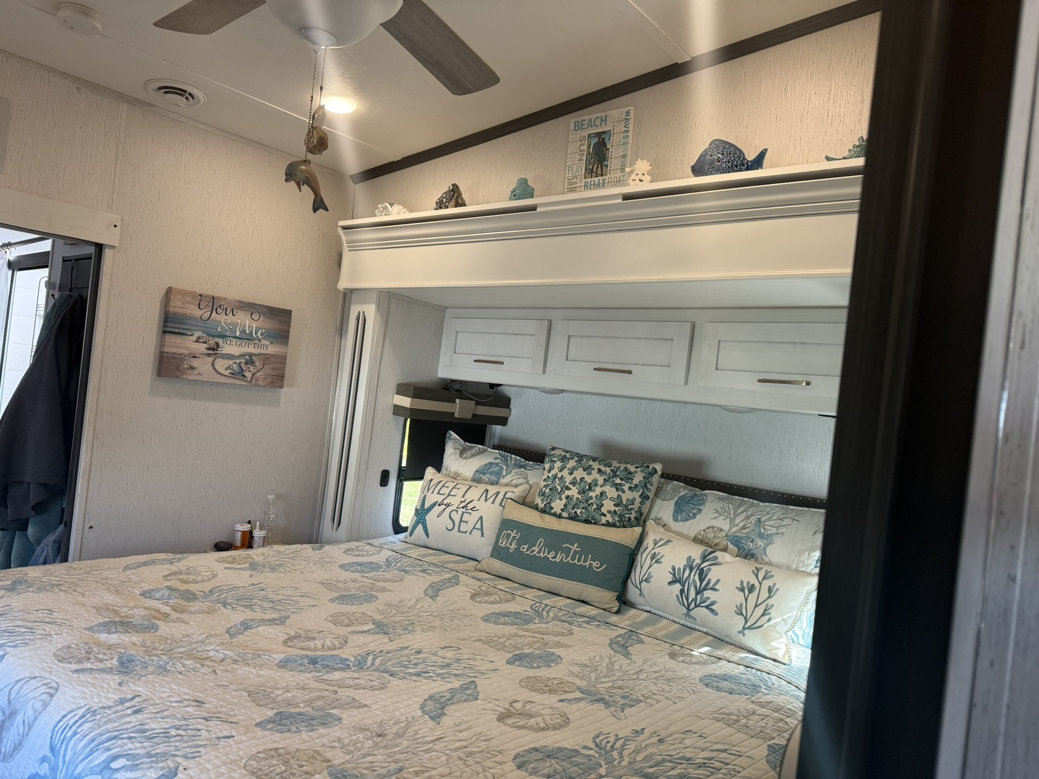 RV bedroom with coastal bedding and storage